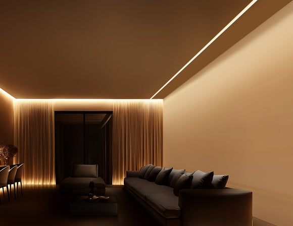 A recessed aluminum lighting fixture is installed along the edge of the hall ceiling, positioned close to the wall. Designed with an angled light-emitting surface, it projects a precise beam that gently washes over the entire wall. The 2700K warm white light creates a cozy and inviting atmosphere. The fixture is seamlessly embedded into the ceiling, maintaining a clean and modern aesthetic. This subtle integration enhances the wall’s texture and depth without disrupting the overall visual harmony of the spa