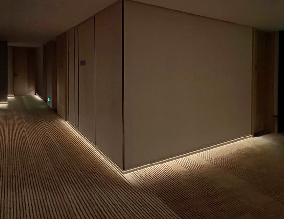 Modern wall skirting aluminum channel J016B with shallow profile, perfect for subtle linear lighting effects.