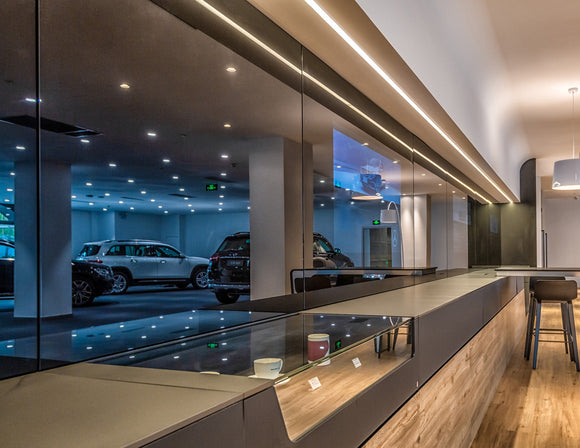 LED strip lights are used in a flexible aluminum channel to create a unique lighting design in a gallery and parking lot.