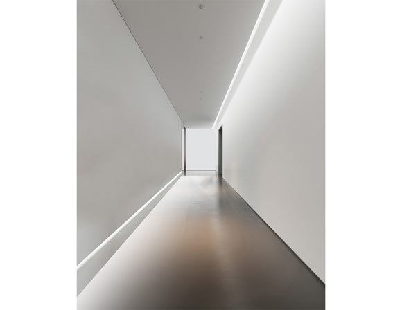 LED strip lights are used in an aluminum channel to illuminate a hallway.
