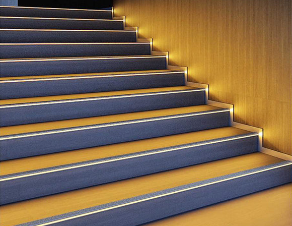 LED strip lights are used in an aluminum channel to illuminate a stairway.