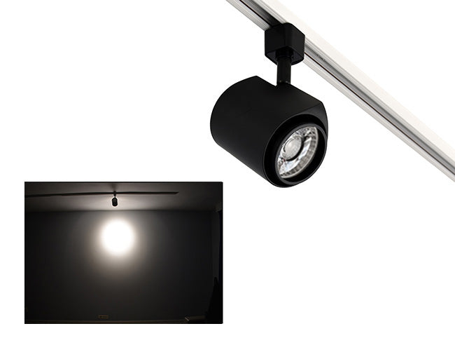 The image showcases the lighting effect produced by a standard track light, revealing a distinct circular bright spot on the wall targeted by the track light.