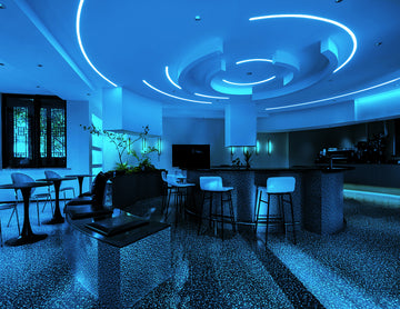 Blue Side Bend neon strip following a graceful curve across the living room ceiling, casting a cool ambient glow and enhancing spatial design.