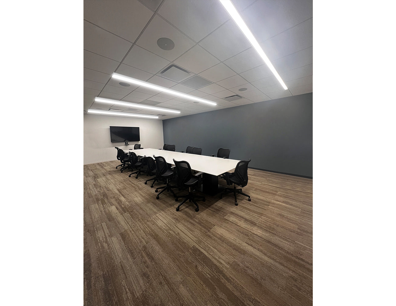 L8070 LED linear light with Convex Lens surface-mounted on small meeting room ceiling, delivering bright and even illumination