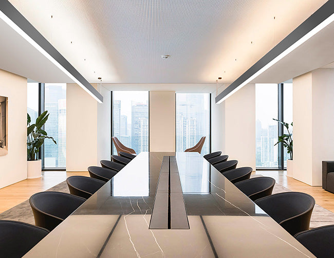 Suspended linear light fixtures formed by GL LED L8070 8ft linear light fixtures illuminate a meeting room.