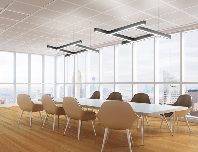 Suspended black linear light fixtures formed by GL LED L8070 T-shaped linear light fixtures illuminate a meeting space.