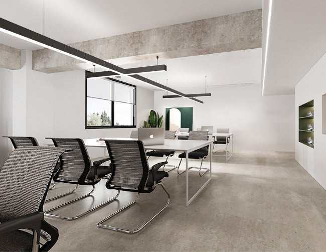 Extended and suspended linear light fixtures formed by GL LED L8070 X-shaped and 4ft straight linear light fixtures illuminate an office area.