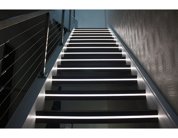 LED strip lights are used in an aluminum channel to illuminate a staircase.