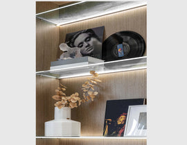 LED strip lights are used in an aluminum channel to create a unique lighting design for a shelving unit.