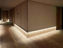 LED strip lights are used in an aluminum channel to illuminate a hallway.