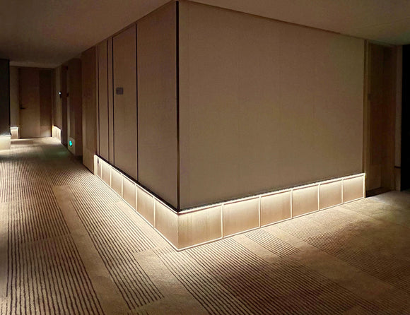 LED strip lights are used in an aluminum channel to illuminate a hallway.