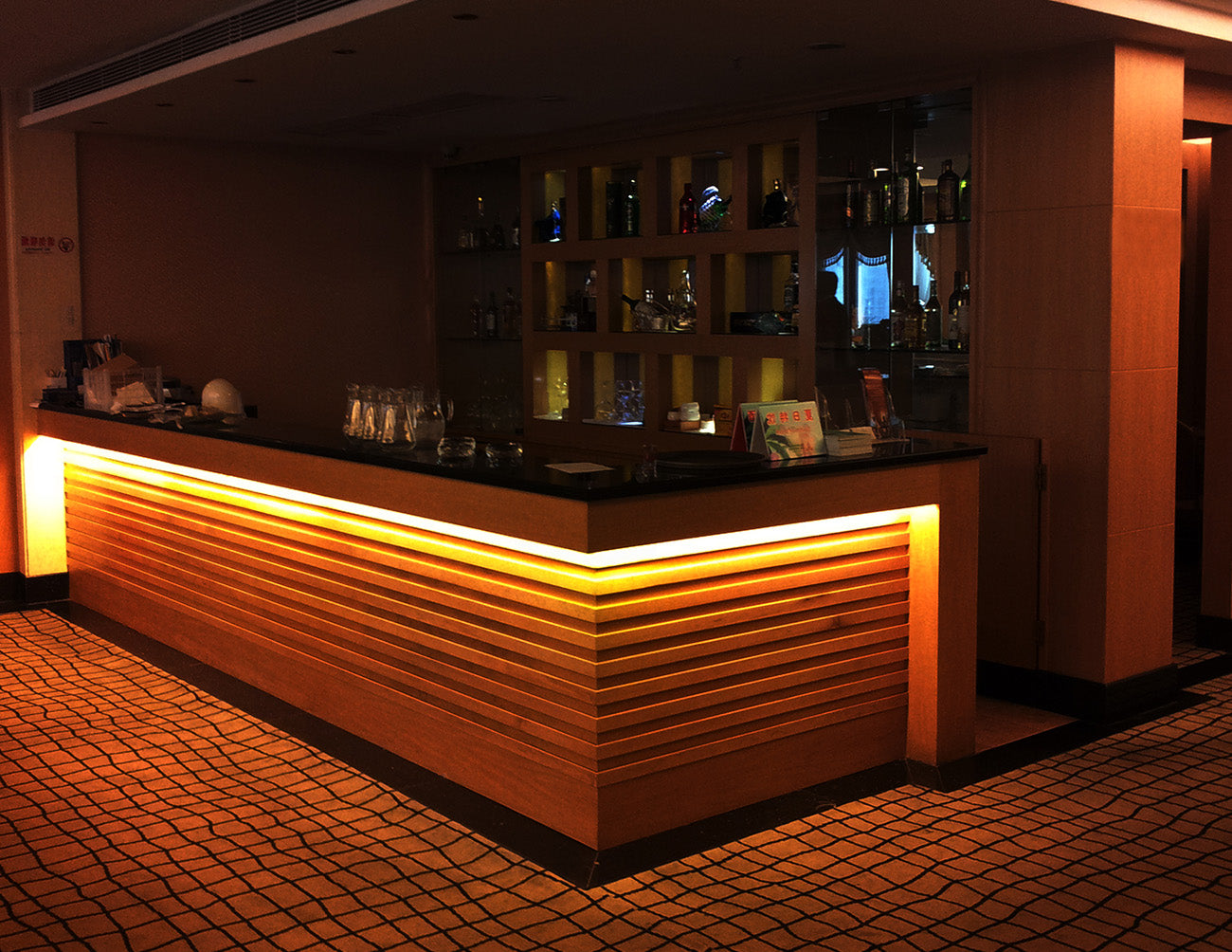 LED Strip Light - Single Color - Super Bright - White PRO - Dry Location IP20 - 24V, casting a soft, ambient glow that highlights the bar’s sleek design. The warm illumination enhances the texture of the materials and creates an inviting, modern atmosphere.