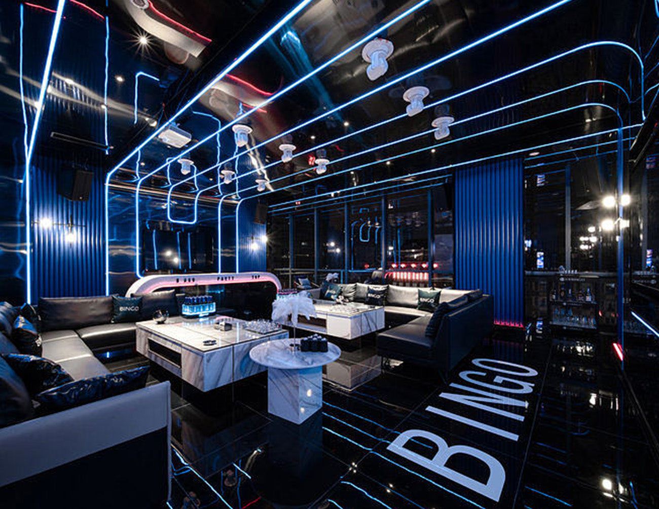 RGB+W LED Strip Light - 24V Color-Changing LED Tape with 3000K White Light Installed in a Bar - Creating a futuristic, tech-inspired ambiance with dynamic color effects and warm white lighting throughout the bar's key areas.