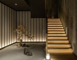 A warm toned staircase is decorated with LED strip lights that are powered by a dimmable LED low voltage power supply. LED strip lights have many commercial and residential lighting design applications, including undercabinet light options and seamless LED strip designs.