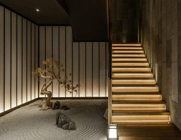 A warm toned staircase is decorated with LED strip lights that are powered by a dimmable LED low voltage power supply. LED strip lights have many commercial and residential lighting design applications, including undercabinet light options and seamless LED strip designs.