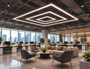 GL LED US LIGHTING L Shape LED Linear Light forming layered suspended square lighting above a modern open-plan commercial office and collaborative lounge.
