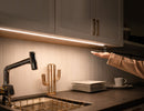 Recessed undercabinet LED strip lighting with integrated hand sensor control, providing uniform 3000K warm white task illumination for modern kitchen architectural projects
