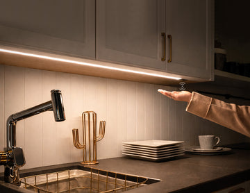 Recessed undercabinet LED strip lighting with integrated hand sensor control, providing uniform 3000K warm white task illumination for modern kitchen architectural projects