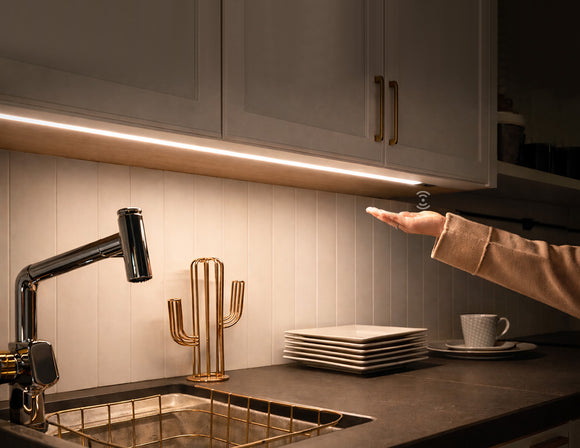 Recessed undercabinet LED strip lighting with integrated hand sensor control, providing uniform 3000K warm white task illumination for modern kitchen architectural projects