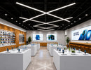 GL LED US LIGHTING X Shape LED Linear Light creating suspended geometric lighting above product displays in a modern electronics retail store.
