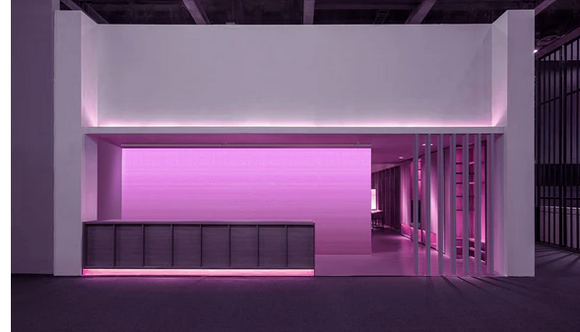 A corporate reception area with a colorful wall-wash lighting illuminating the back wall, creating a modern and tech-savvy brand impression.