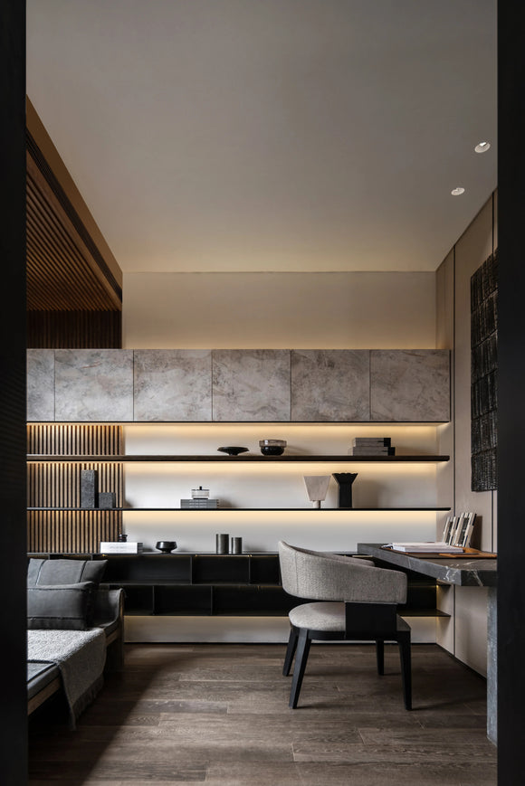 LED strip light installed in aluminum channel for bookshelf shelf lighting, providing uniform architectural illumination in a modern study interior.