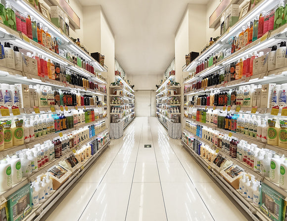 Magnetic Shelf Power Distribution Track installed in retail shelving, providing continuous power distribution and uniform LED lighting throughout a supermarket aisle.