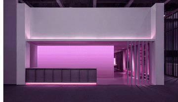 Office reception area with a gradient-colored wall wash light behind the desk, highlighting the company’s dynamic and innovative spirit.
