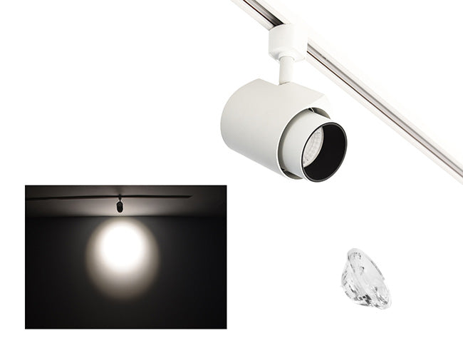 The image showcases the lighting effect produced by a white color track light with snoot and a 15° lens, revealing a distinct circular bright spot on the wall targeted by the track light.