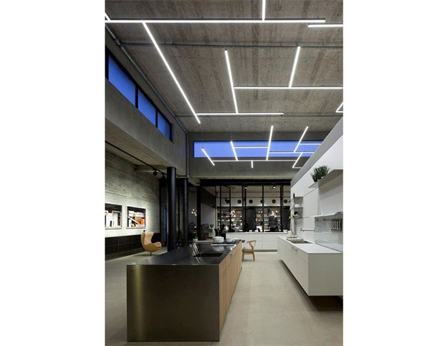 A few LED strip light fixtures using A-2525 aluminum channels are suspended on the ceiling to illuminate the kitchen island and cabinet area.