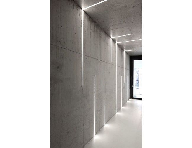 LED strip lights fixtures with aluminum channel flat recess ES-3011 are installed on the wall and ceiling of a corridor space.