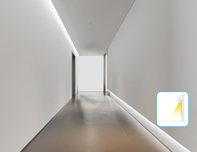 LED strip light fixtures using wall washer GL 085 aluminum channels are installed at the bottom of a wall to produce a wall washer lighting effect downward in a corridor space.