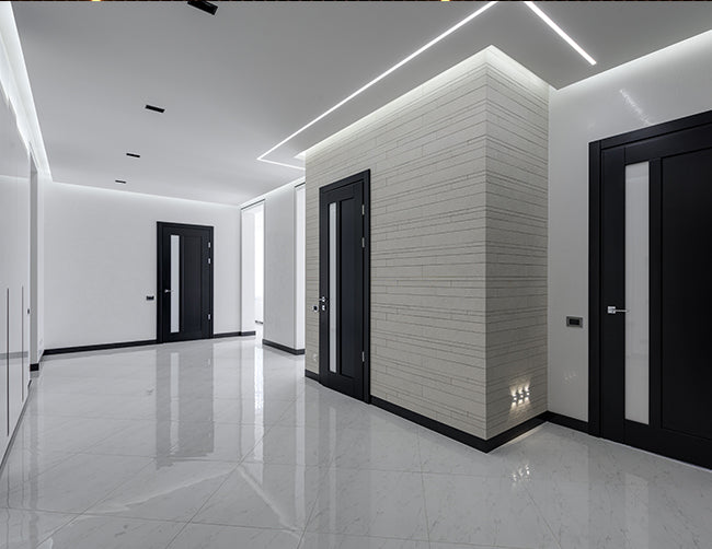 LED strip light fixtures using slim trimless recess GL 079 channels are installed on the ceiling of a corridor area.