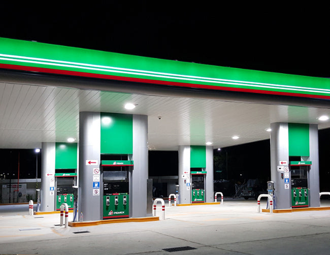 Many LED Gas Station Canopy Lights are illuminating a gas station.