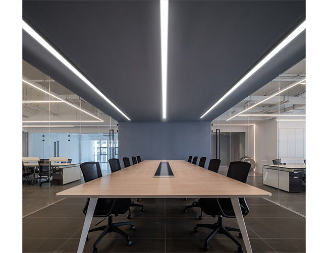 Extended ceiling surface mounted GL LED L8456 linear light fixtures illuminate a conference room.