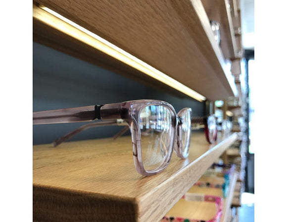 LED strip lights are used in an aluminum channel to illuminate a retail space shelving unit.