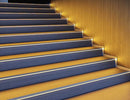 LED strip lights are used in an aluminum channel to illuminate a stairway.