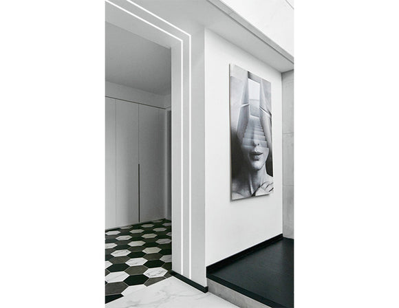 LED strip lights are used in an aluminum channel to illuminate a hallway.