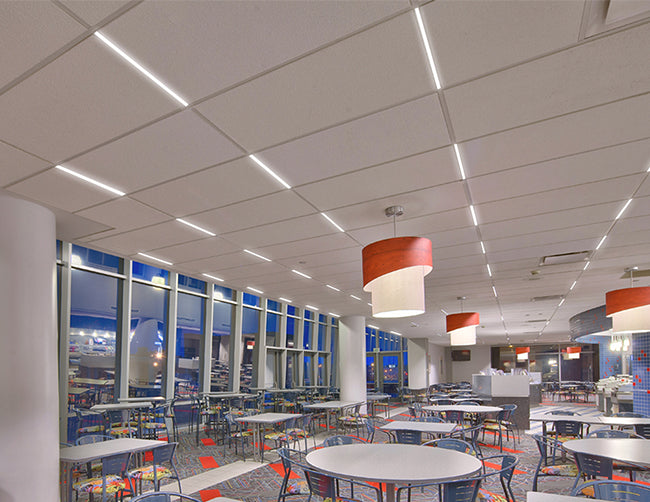 Five rows of LED T Grid Linear Light illuminating a large dining area.