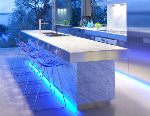 LED 3D neon blue lights are used under a kitchen island to light floors in a kitchen.
