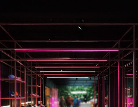 LED RGBW strip lights show pink color and are installed in a walking area.