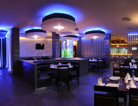 LED RGB strip lights are used for cove lighting in a restaurant area.