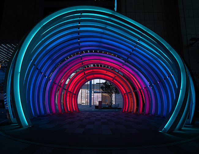 A walkway is decorated with wet rated RGB LED strip lights that are powered by a dimmable low voltage transformer.