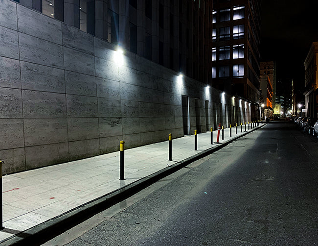 LED Full-Cutoff Wall Pack Light 70W installed and illuminating along a street.