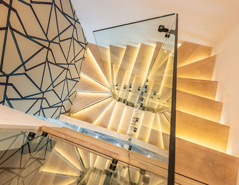 LED strip lights for stair lighting illuminate a downward stairway.